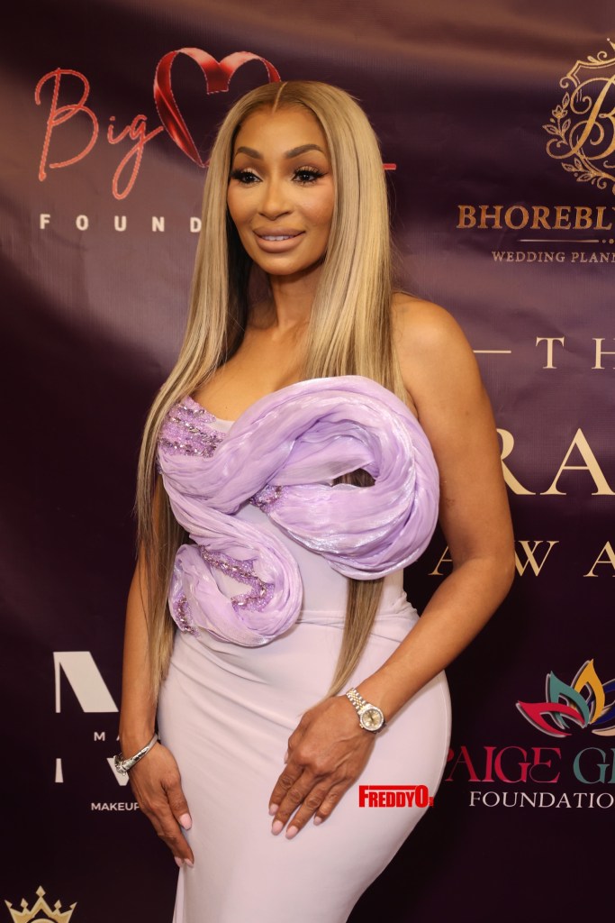 Karlie Redd smiles on the red carpet in front of the Big Heart Foundation backdrop at the 2nd Annual Courageous Awards in Atlanta
